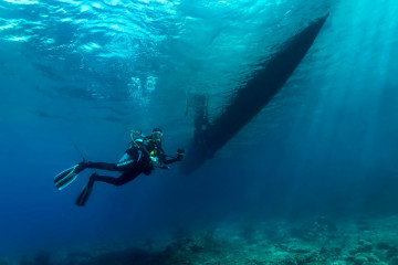 Philippines, Moalboal, Diver underneath Boat